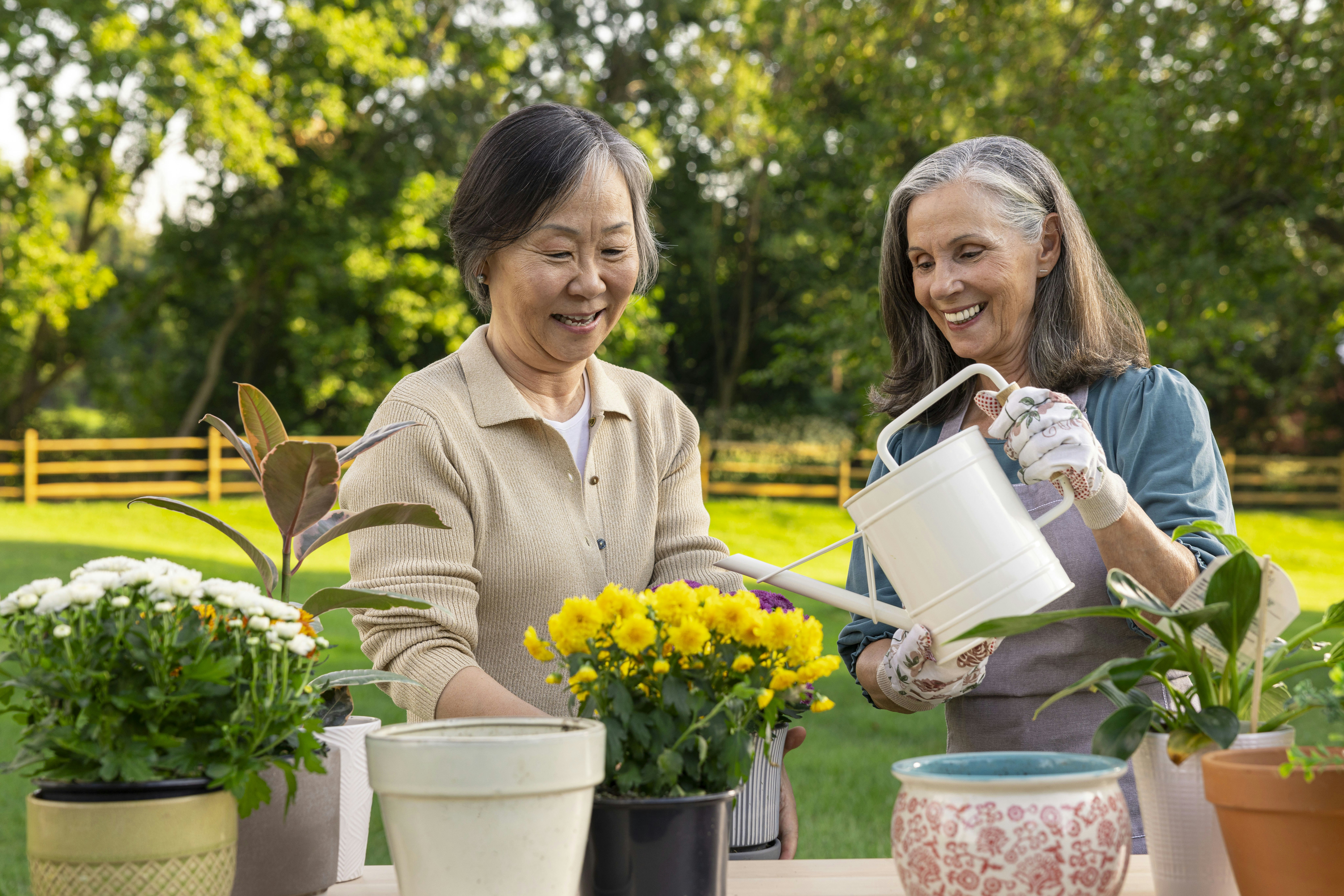 Two women tend to flowers in an outdoor setting