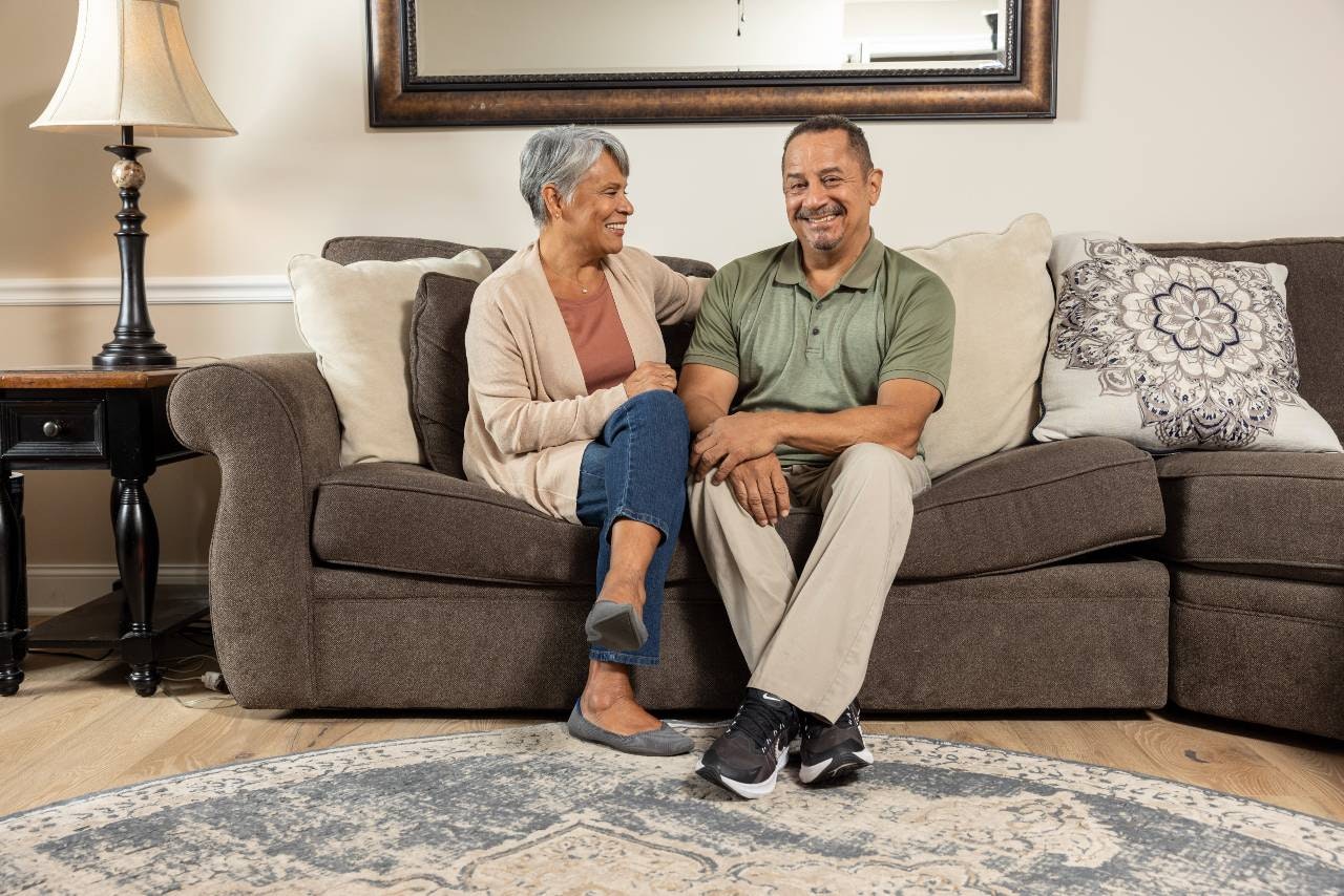 Two family members sit side-by-side on a couch