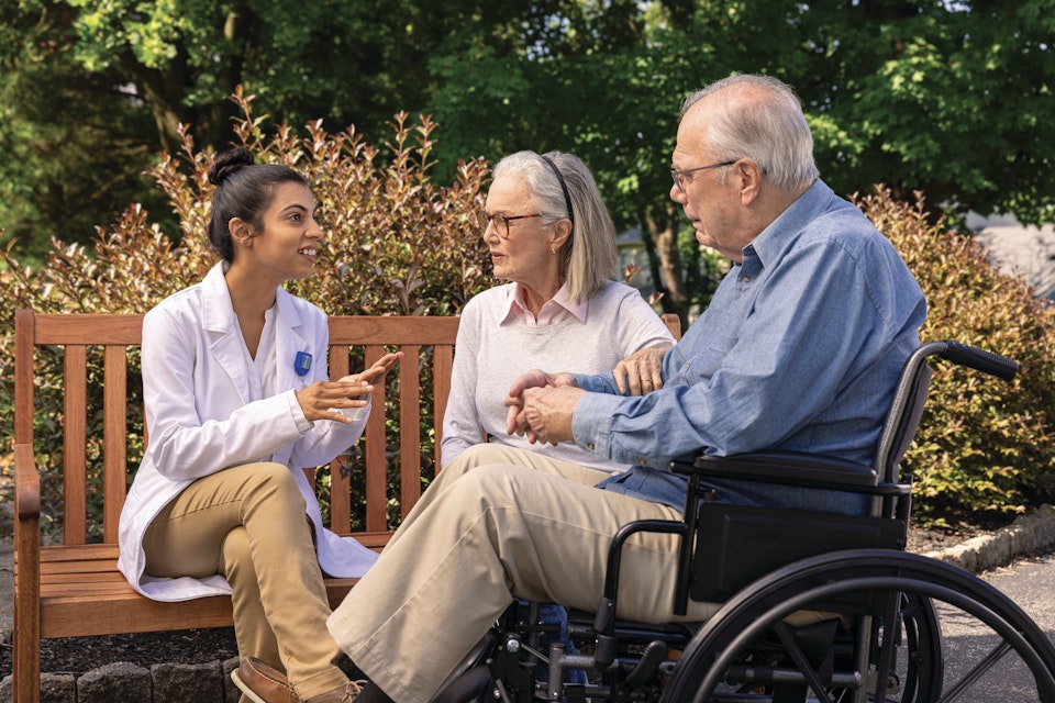 A provider in a lab coat speaks with a couple